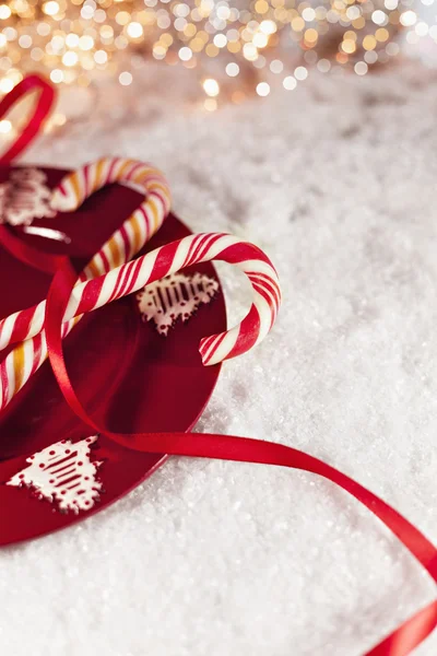 Bastones de caramelo en la placa roja con la decoración de Navidad alrededor — Foto de Stock