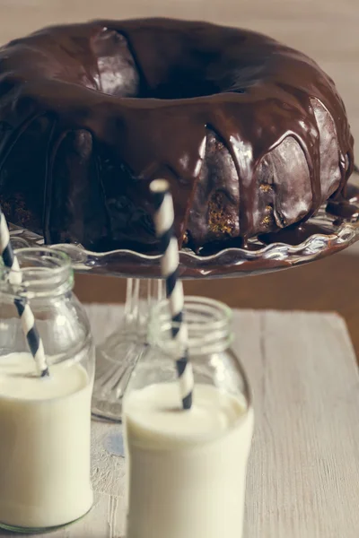 Gâteau Bundt et deux bouteilles de lait avec des pailles — Photo