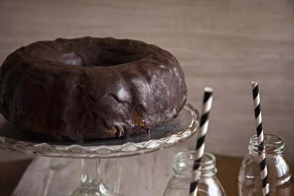 Bolo de pacote e duas garrafas com palhas — Fotografia de Stock