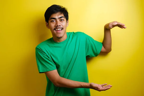 Usmívající Pohledný Asijský Muž Ukazující Prstem Prázdné Otevřené Ruce Izolované — Stock fotografie