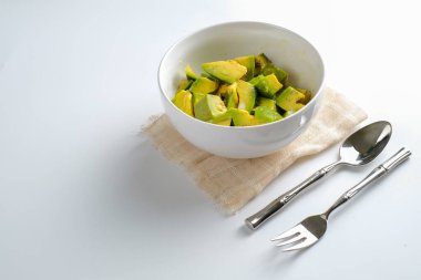 Beyaz arka planda izole edilmiş bir kâse avokado dilimi.