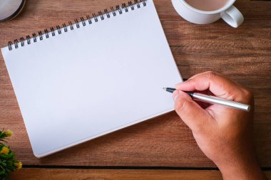 Tahta masa, defter, büyüteç, kalem, dekoratif bitkiler. Kopyalama alanı olan üst görünüm, düz yatay.