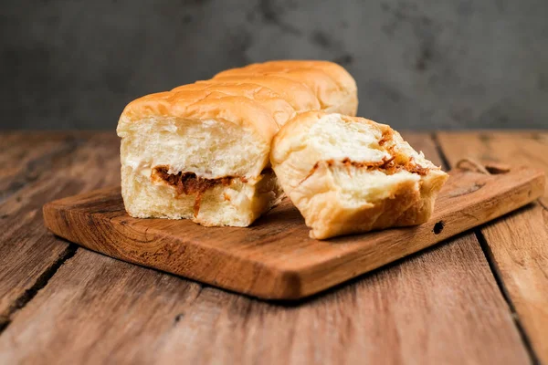 Torn bread filled with beef floss and mayonnaise on a wooden table