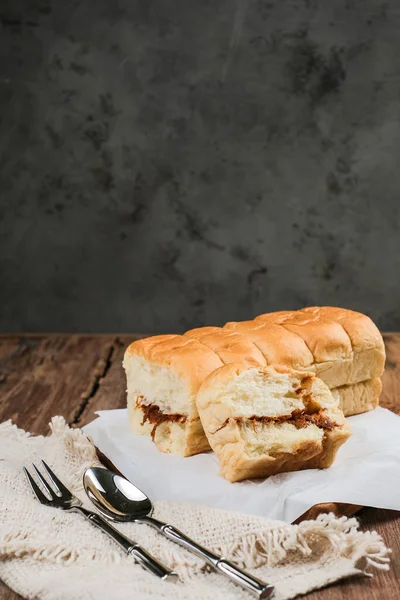 Torn bread filled with beef floss and mayonnaise on a wooden table