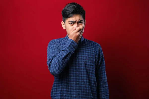 Young Asian Man Wearing Casual Shirt Red Background Smelling Something — Stockfoto