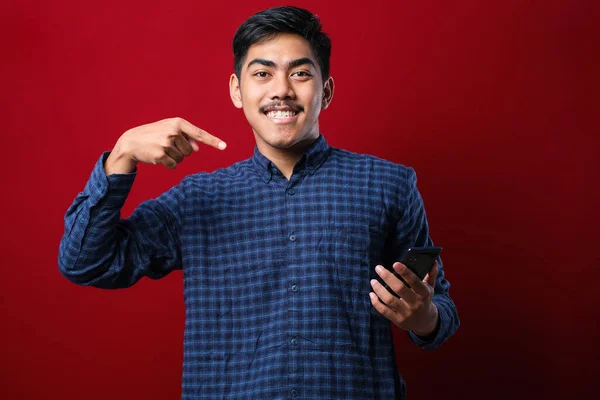 Young Handsome Man Using Smartphone Wearing Casual Shirt Isolated Red — Stockfoto