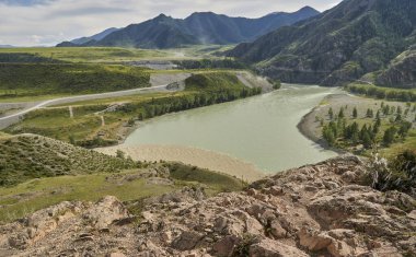 Dağ nehri boyunca dağlardaki otoyolda. Altai.