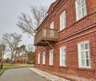 Ahşap oymalı balkonlu eski kırmızı tuğla bina.