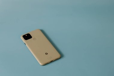Ottawa, Ontario, Kanada - 7 Ocak 2021: Bir Google Pixel 5 akıllı telefonu 'Sorta Sage' renginde düz mavi bir yüzey üzerinde yüzükoyun yatıyor.