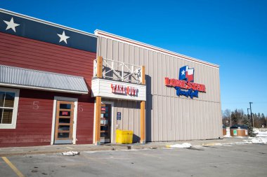 Ottawa, Ontario, Kanada - 8 Ocak 2021: Ottawa 'daki Hunt Club Road' un bitişiğindeki Lone Star Teksas Mangal Restoranı 'nın paket servis girişi.