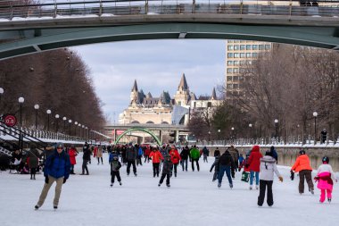 Ottawa, Ontario, Kanada - 6 Şubat 2021: İnsanlar Ottawa şehir merkezindeki Rideau Kanal Skateway boyunca buzda kayıyorlar, bazıları COVID-19 salgını sırasında maske takmayı seçiyor..