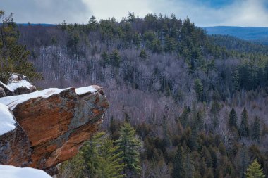 Kışın, Kartal Yuvası Gözcüleri, Calabogie, Ontario, Kanada 'daki kayalıkların üzerinden kar yağar. Ontario 'nun doğu dağlarının tepeleri arkasında görülüyor..