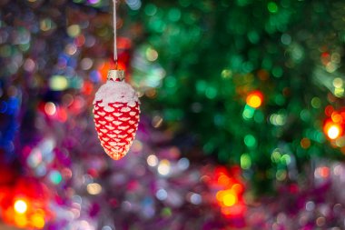 Eski bir Sovyet Noel ağacı oyuncağı. Arka planda çok renkli süslemeler ve parıldayan bir çelenk var..