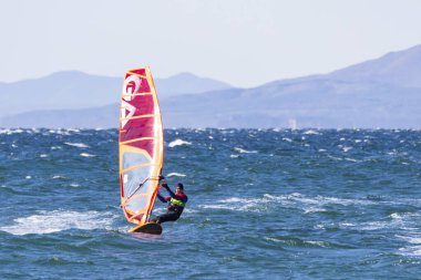 Vladivostok, Rusya - Ekim 05, 2019 Vladivostok 'taki Amur Körfezi' nde rüzgarlı bir sonbahar gününde deniz dalgaları üzerinde rüzgar sörfçüleri.