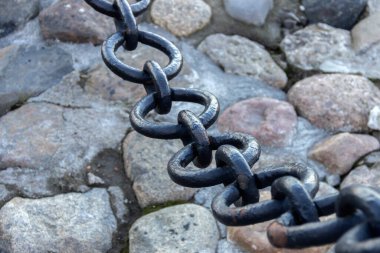 Eski dövülmüş paslı zincir, zemininde döşeme taşlarının boyası soyulmuş..