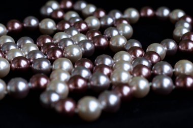 Siyah kadifede farklı renkte incilerin kolyesi.