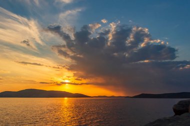 Bir yaz akşamında, bulutların arasında, denizde gün batımını resmediyorum. Tobisina Burnu, Rus adası, Vladivostok.