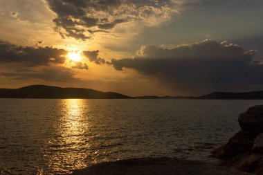 Bir yaz akşamında, bulutların arasında, denizde gün batımını resmediyorum. Tobisina Burnu, Rus adası, Vladivostok.