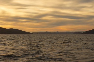 Bir yaz akşamında, bulutların arasında, denizde gün batımını resmediyorum. Tobisina Burnu, Rus adası, Vladivostok.