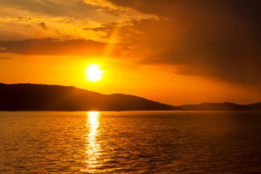 Bir yaz akşamında, bulutların arasında, denizde gün batımını resmediyorum. Tobisina Burnu, Rus adası, Vladivostok.