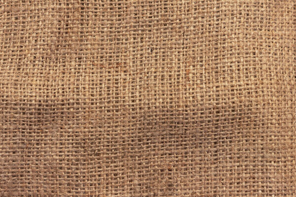 The texture of an uneven crumpled, roughly woven burlap.