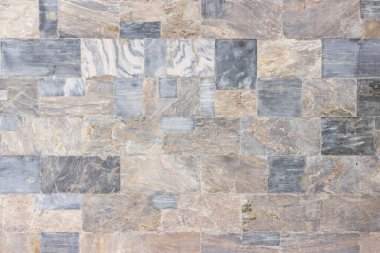 Binanın duvarı çeşitli renk ve boyutlarda cilalanmış mermer levhalarla karşılaşıyor.. 