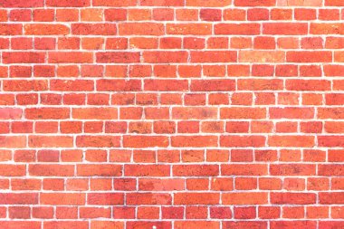 Yıpranmış ve solmuş yüzeyi olan eski, çatlak tuğlalardan oluşan bir duvar. Eski bir evin yenilenmiş tuğlası..