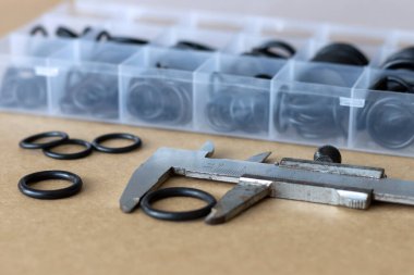 Lastik O halkasının çapını kalibre ile ölçüyorum. Eski bir ölçüm aracı ve pnömatikler ve hidrolikler için bir set conta.