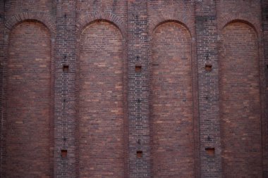 Aralıkları ve çıkıntılı parçaları olan geniş eski bir tuğla duvar..