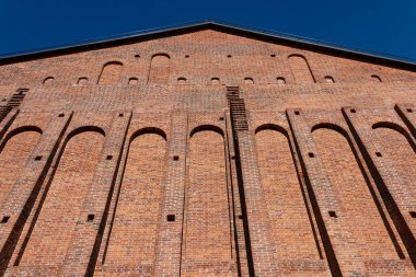 Aralıkları ve çıkıntılı parçaları olan geniş eski bir tuğla duvar..