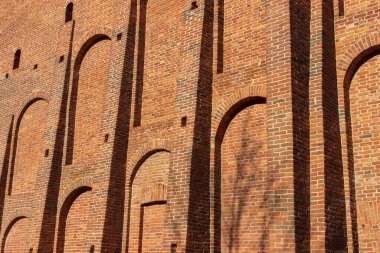 Aralıkları ve çıkıntılı parçaları olan geniş eski bir tuğla duvar..