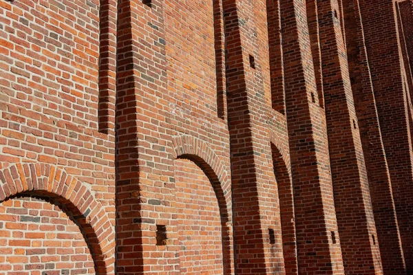 Aralıkları ve çıkıntılı parçaları olan geniş eski bir tuğla duvar..