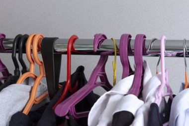 Ergen kıyafetleri ve okul üniformaları olan bir askı. Ev depolama sistemi.