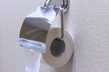 Tuvaletteki duvardaki tutacakta bir rulo tuvalet kağıdı..