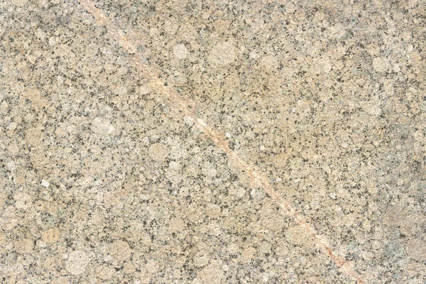 The texture of a hewn granite slab with a colorful pattern. Facing material for walls made of natural stone.
