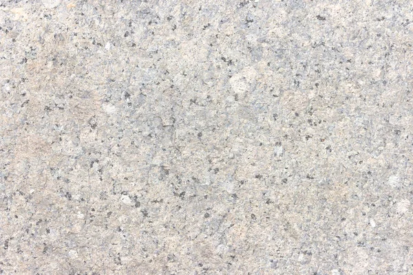 The texture of a hewn granite slab with a colorful pattern. Facing material for walls made of natural stone.