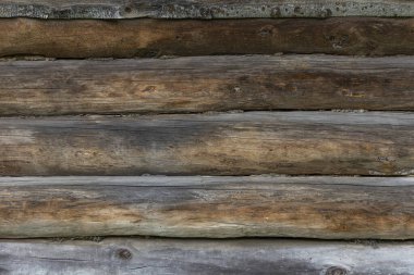 Tahtalardan yapılmış eski ahşap bir duvarın yüzeyi zamanla ve havayla karardı. Geleneksel Rus yapımı ahşaptan evler.