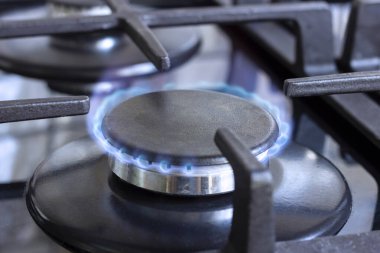 Mutfakta yanan bir gaz ocağı. Evde doğal gaz kullanımı..