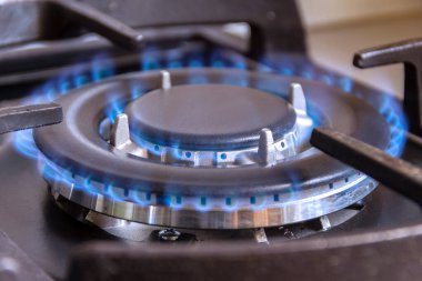 Mutfakta yanan bir gaz ocağı. Evde doğal gaz kullanımı..