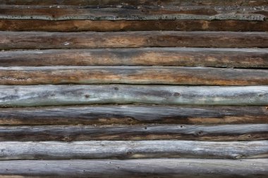 Tahtalardan yapılmış eski ahşap bir duvarın yüzeyi zamanla ve havayla karardı. Geleneksel Rus yapımı ahşaptan evler.