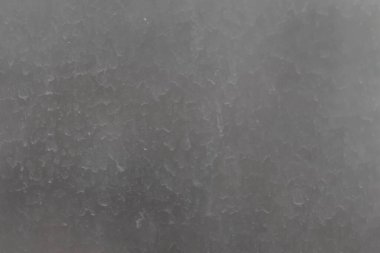 Kirli pencere camının yüzeyi, tozlu yağmur damlalarıyla kaplı. Bulanık soyut doku.