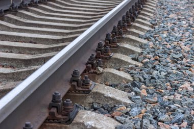 Demiryollarını beton yataklı vagonlara bağlayan cıvatalar. Demiryolu bağlantıları yakın planda..