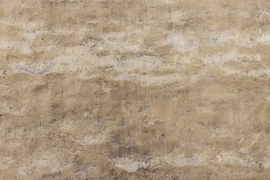 Yıkık dökük alçılı eski bir evin eski püskü duvarı. Sarı-gri soyut doku.