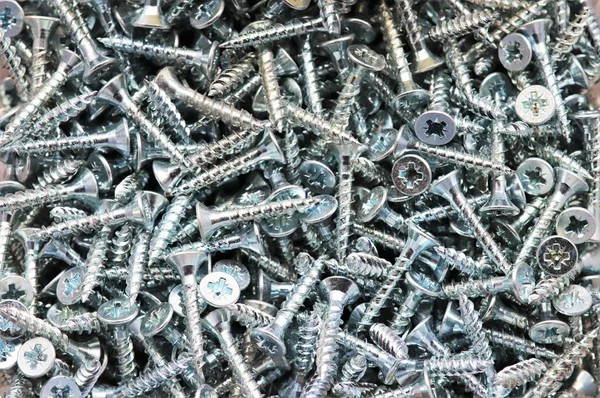 Mass of galvanised silver wood screws as a background