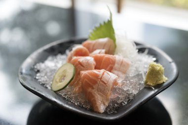 Taze somon sashimi plaka siyah masada dansöz