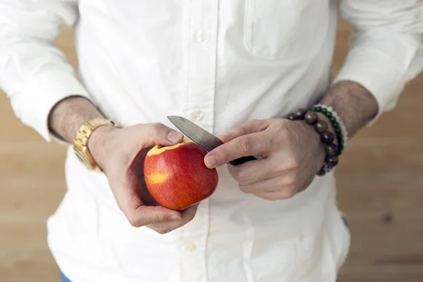 Hand med kniv peeling äpple huden — Stockfoto