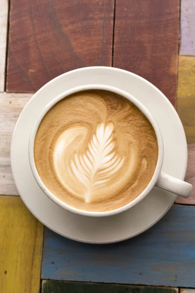 Dwie filiżanki kawy z latte art na drewnianym stole — Zdjęcie stockowe