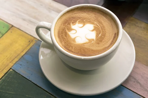 Dwie filiżanki kawy z latte art na drewnianym stole — Zdjęcie stockowe