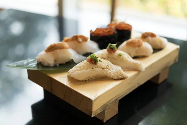 Set de sushi sobre plato de madera sobre mesa —  Fotos de Stock