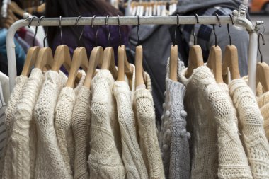 Bej renk raf giysilerindeki kazak örgü